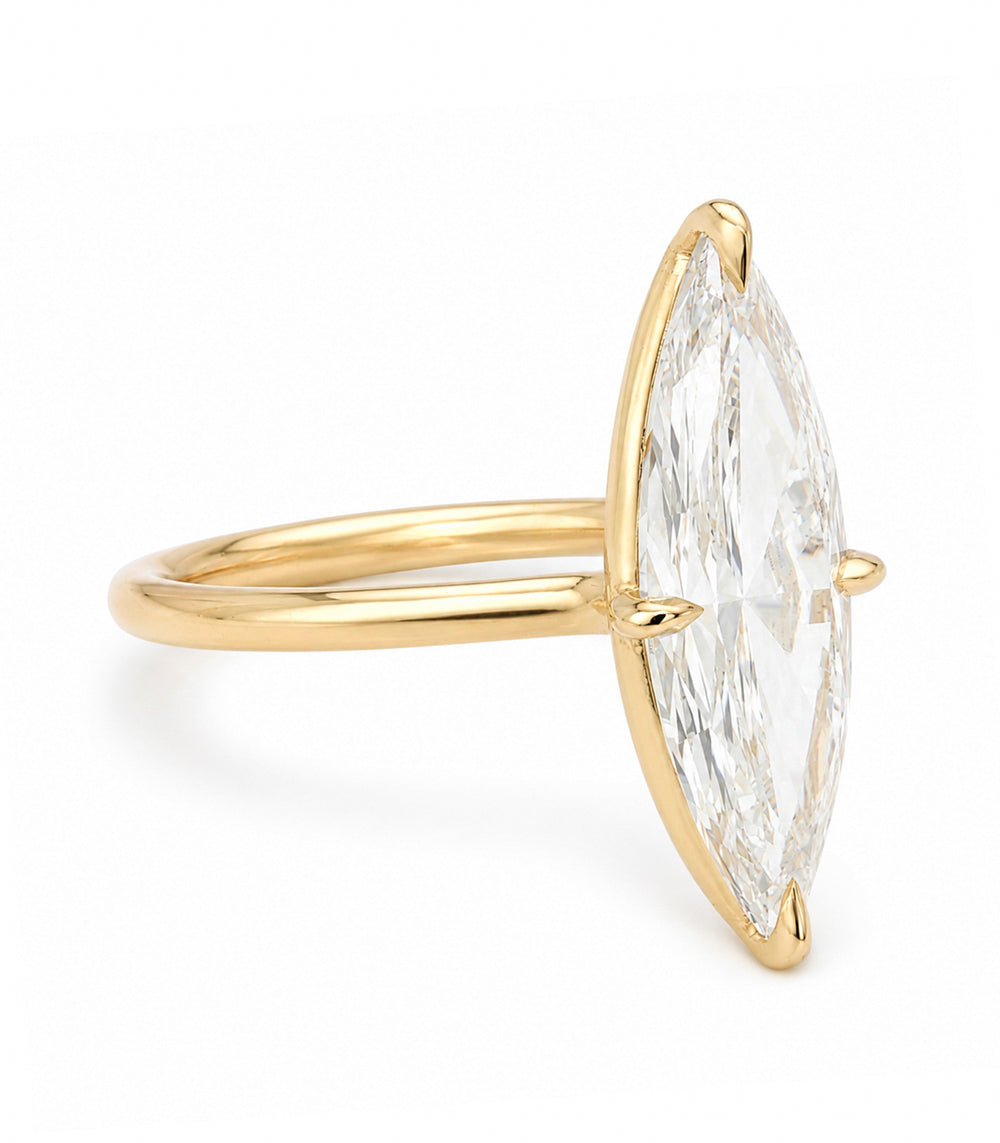 A yellow gold solitaire engagement ring featuring a moval old mine-cut white diamond in a prong setting, shown on a clean white background.