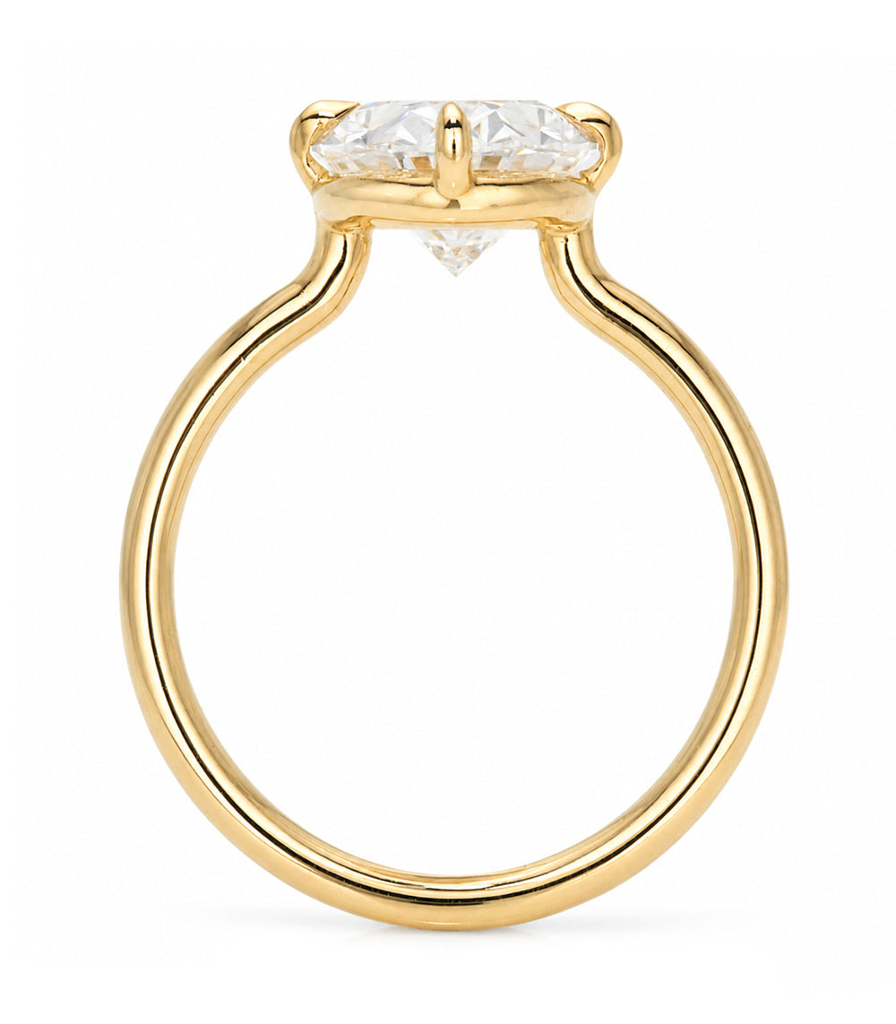 A yellow gold solitaire engagement ring featuring a moval old mine-cut white diamond in a prong setting, shown on a clean white background.