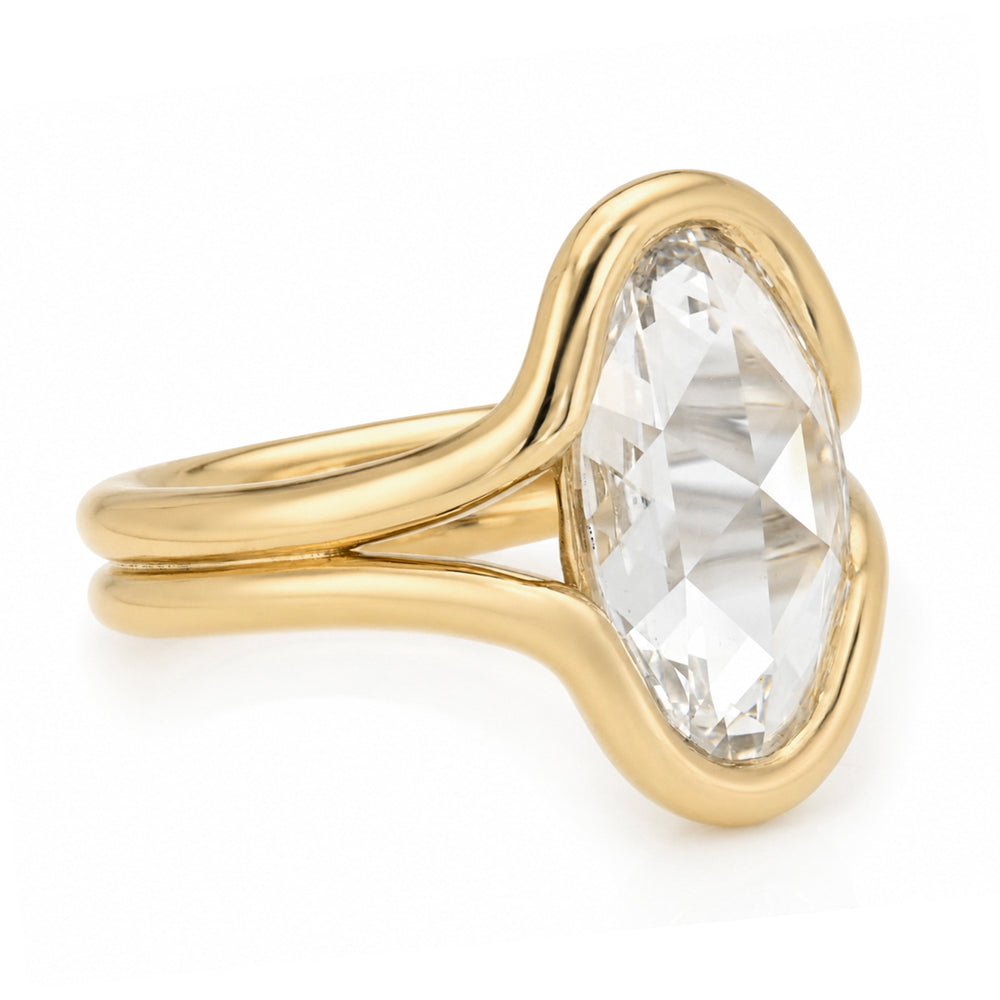 A yellow gold solitaire bezel set double band engagement ring featuring a oval rose cut white diamond in a prong setting, shown on a clean white background.