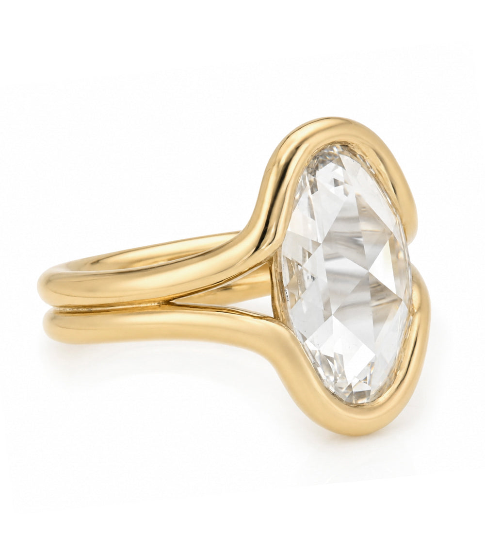 A yellow gold solitaire bezel set double band engagement ring featuring a oval rose cut white diamond in a prong setting, shown on a clean white background.