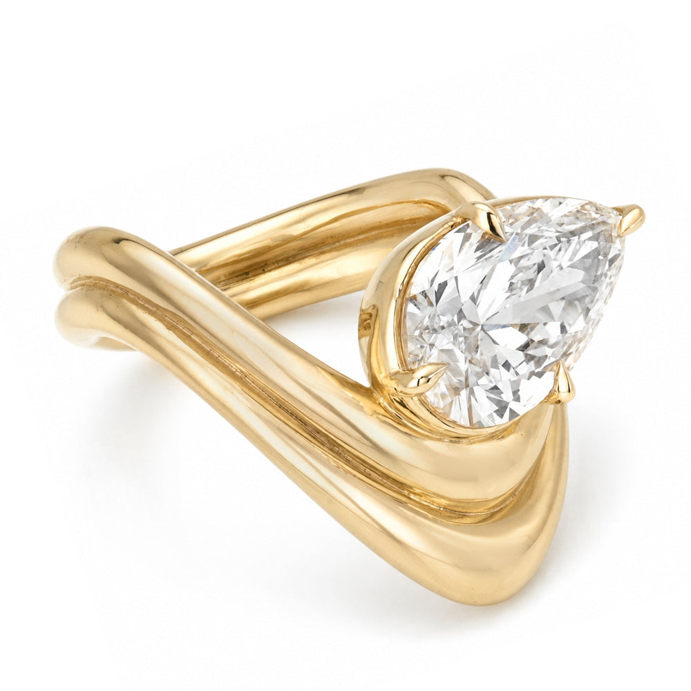 A yellow gold solitaire engagement ring featuring a pear brilliant-cut set in a tilted orientation white diamond in a prong setting with a double contour band shown on a clean white background.