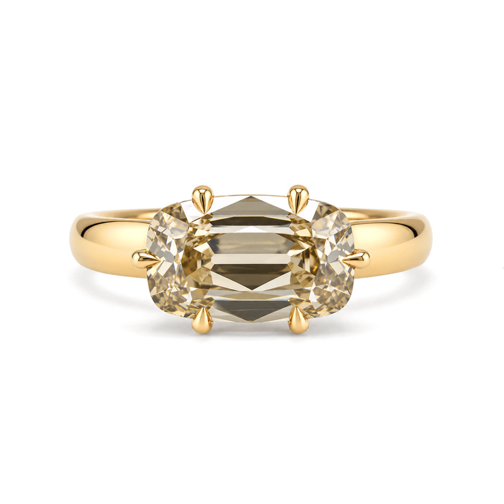 a front view of a warm, toasted colored lab diamond ring set east to west with 6 eagle claw prongs, set low on a wide and tapered band. 