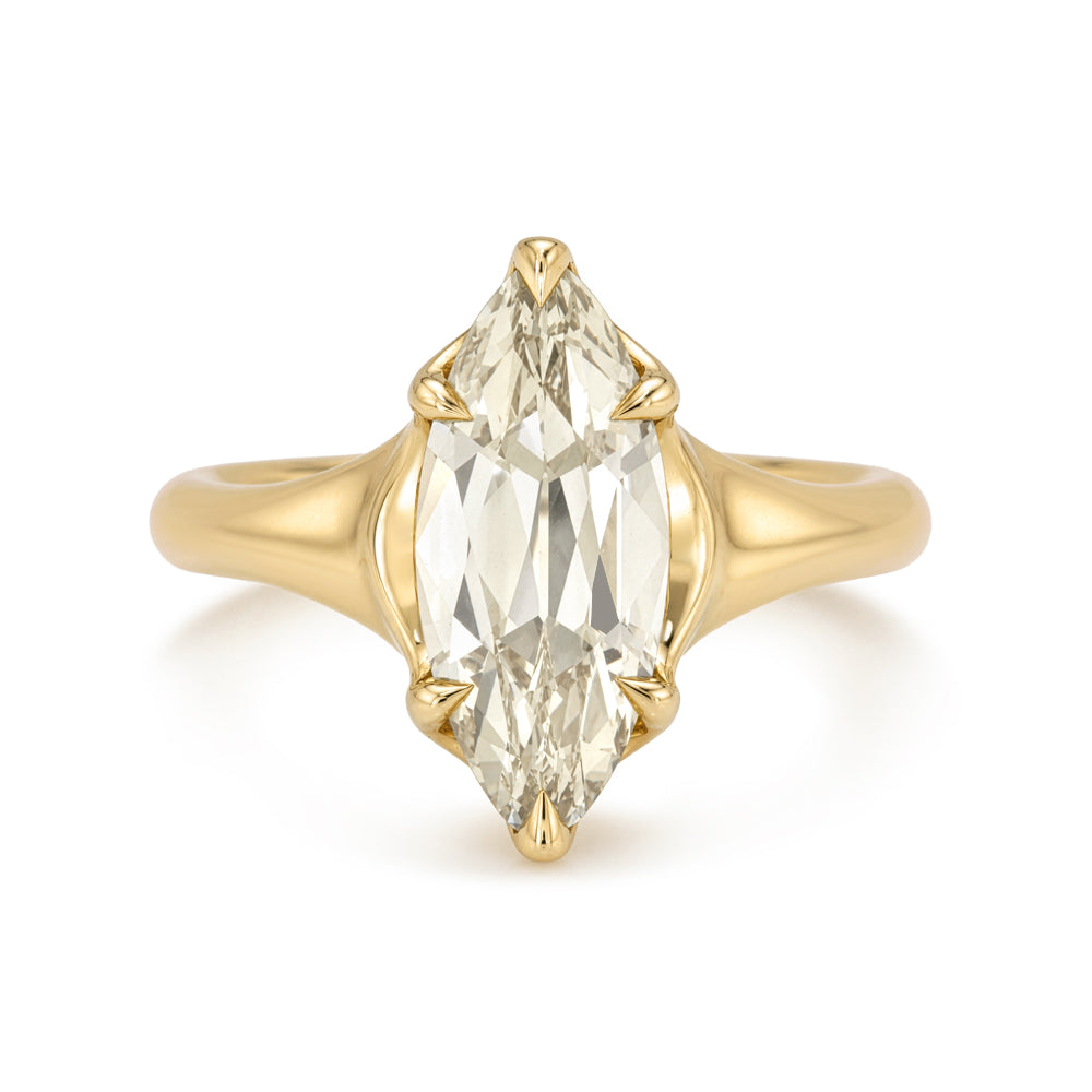A yellow gold ring featuring a large marquise-cut clear gemstone in a four-prong setting, shown against a plain white background.