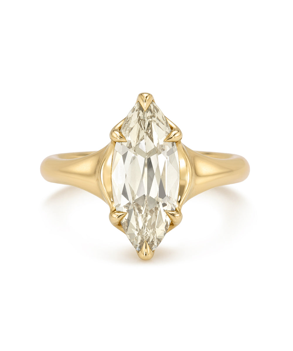 A yellow gold ring featuring a large marquise-cut clear gemstone in a four-prong setting, shown against a plain white background.