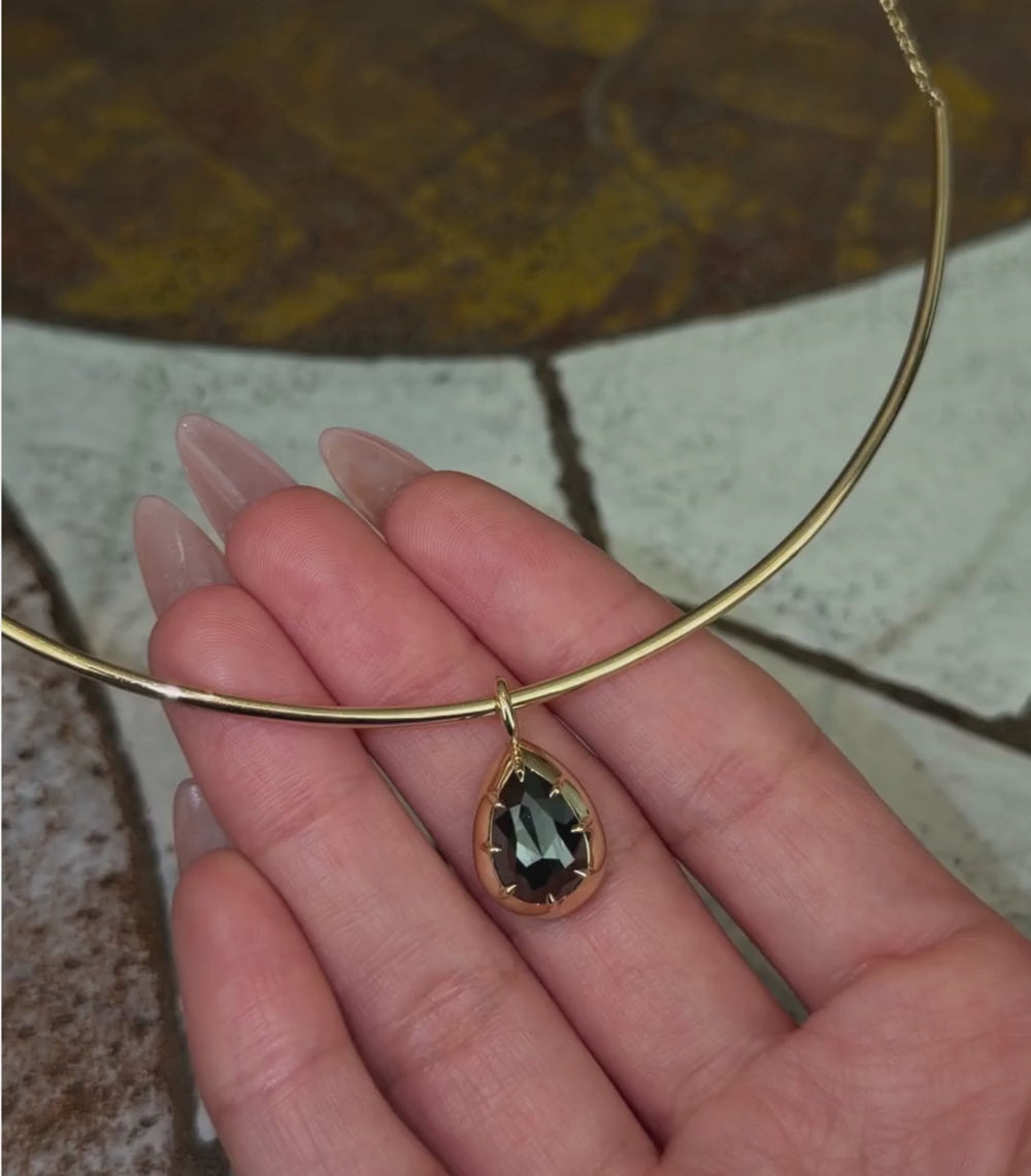 14K yellow gold half collar chain necklace with a black rosecut diamond shown pendant, shown with hands.