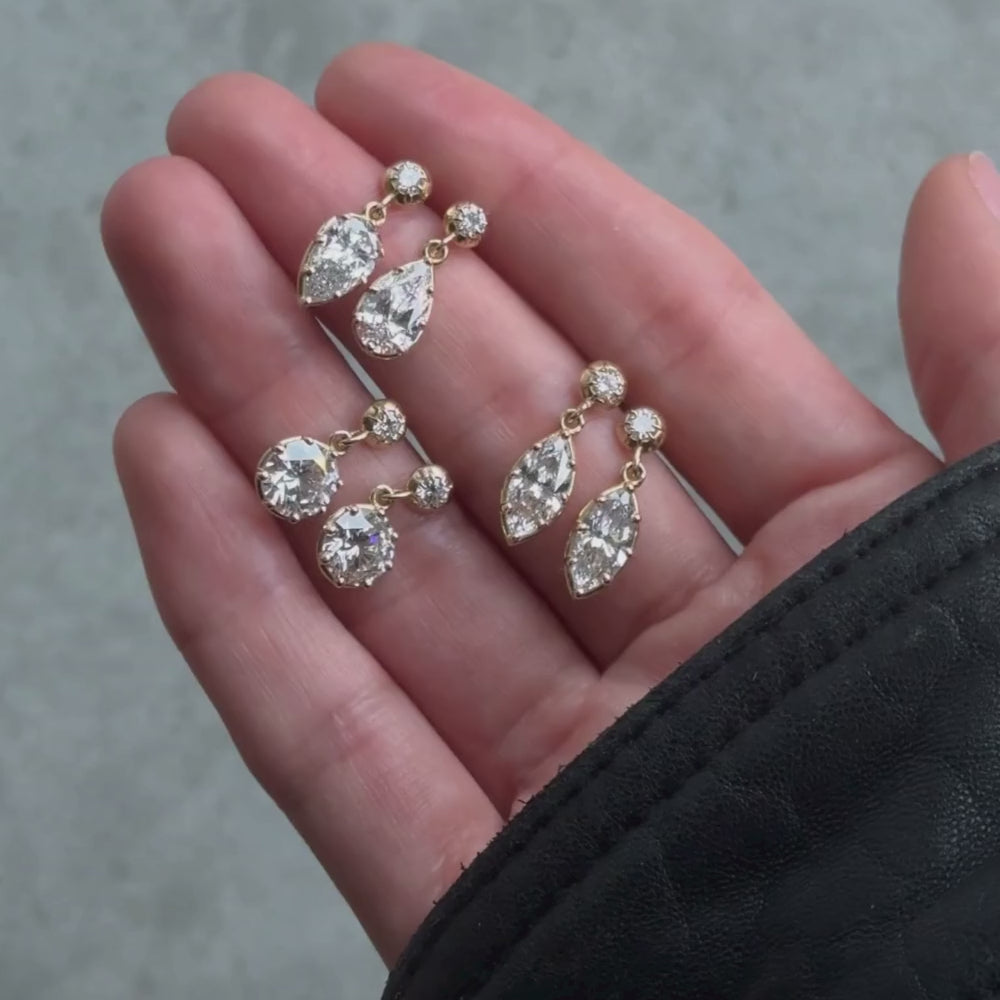Three pairs of Gigi Lab grown dangle earrings displayed on a hand