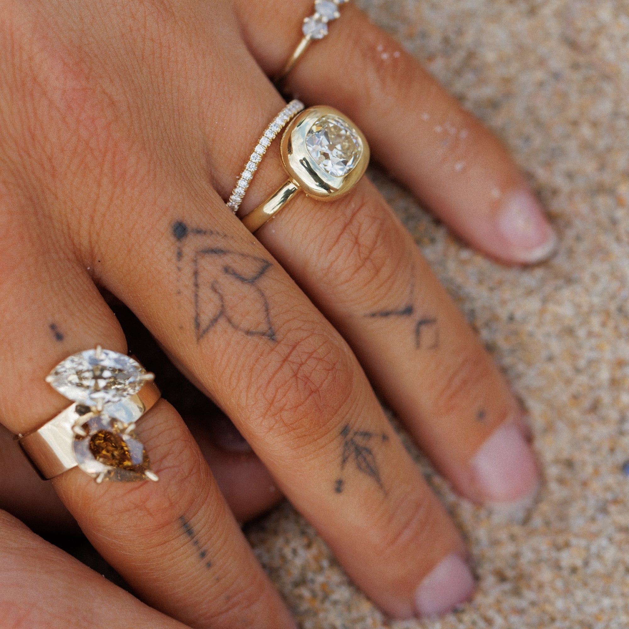 Tattooed Hand In Sand With Natural Champagne Diamond Toi Et Mois Style Rings