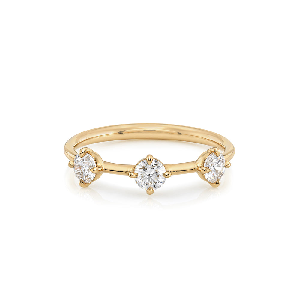 A yellow gold ring featuring three marquise-cut and round-cut clear gemstones set in a delicate three-stone design, photographed on a clean white background.
