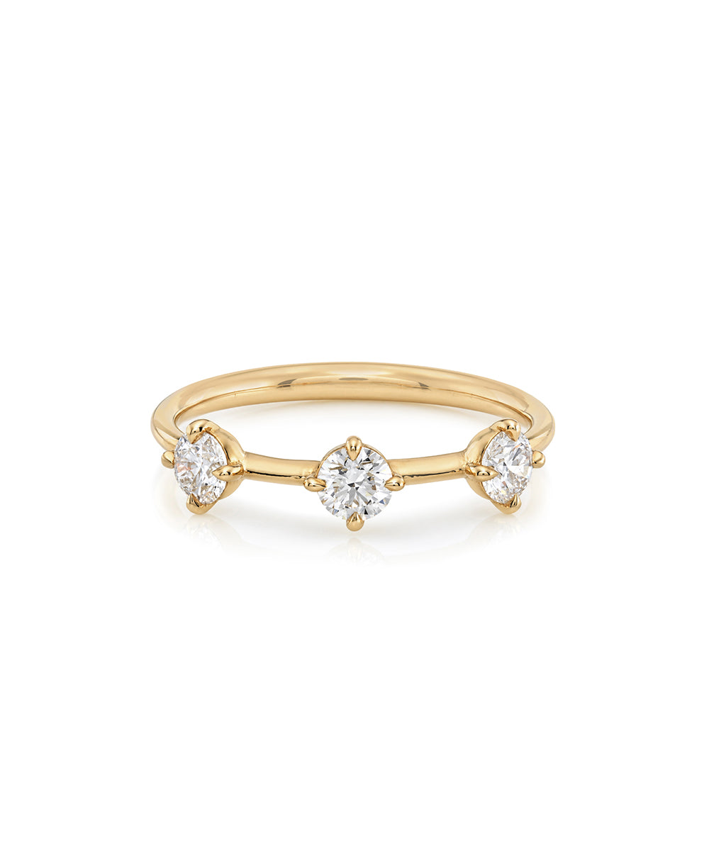 A yellow gold ring featuring three marquise-cut and round-cut clear gemstones set in a delicate three-stone design, photographed on a clean white background.