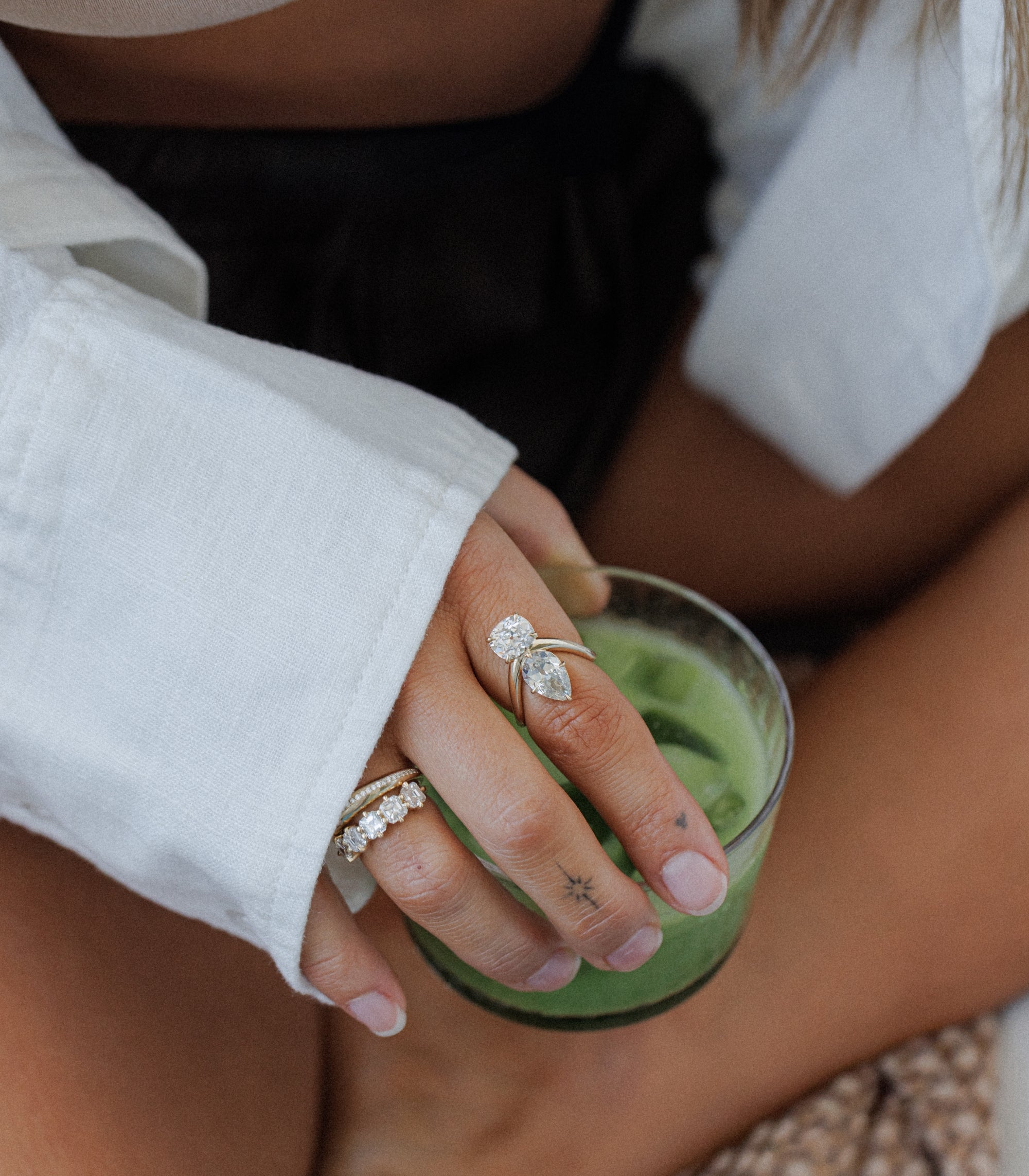 Womans Hand Holding Matcha Latte With Unique Engagement Rings For Contemporary Women Toi Et Moi Designs