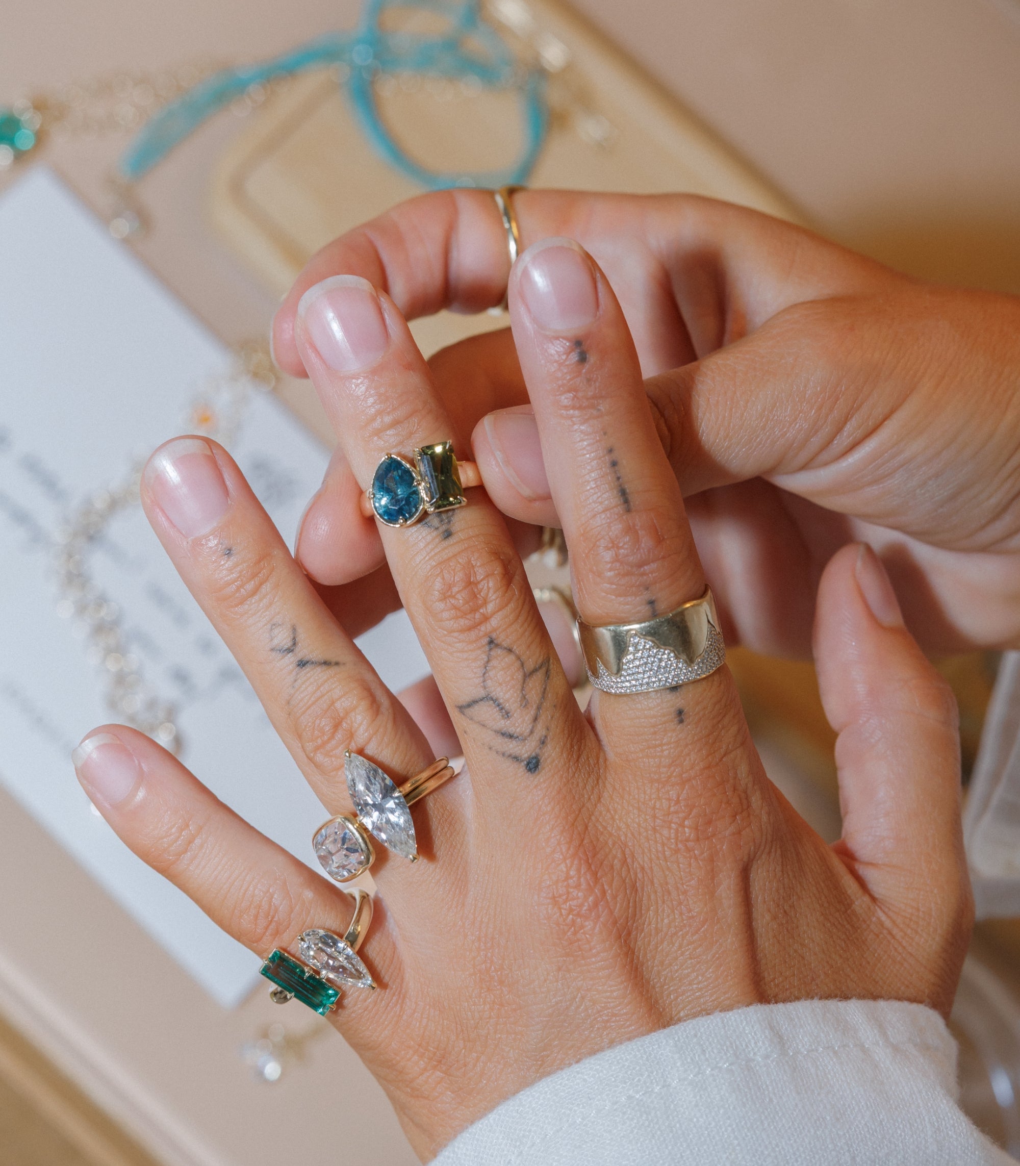 Womans Hands Putting On Stack Of Rings With Sapphire Toi Et Moi Champagne Diamond Solitaire Style Engagement Rings